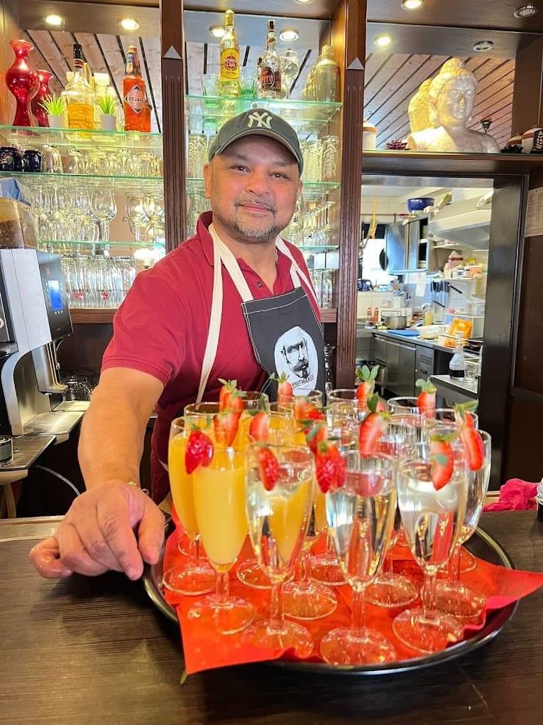 Mario begrüßt seine Gäste an der Bar mit einem Glas Sekt